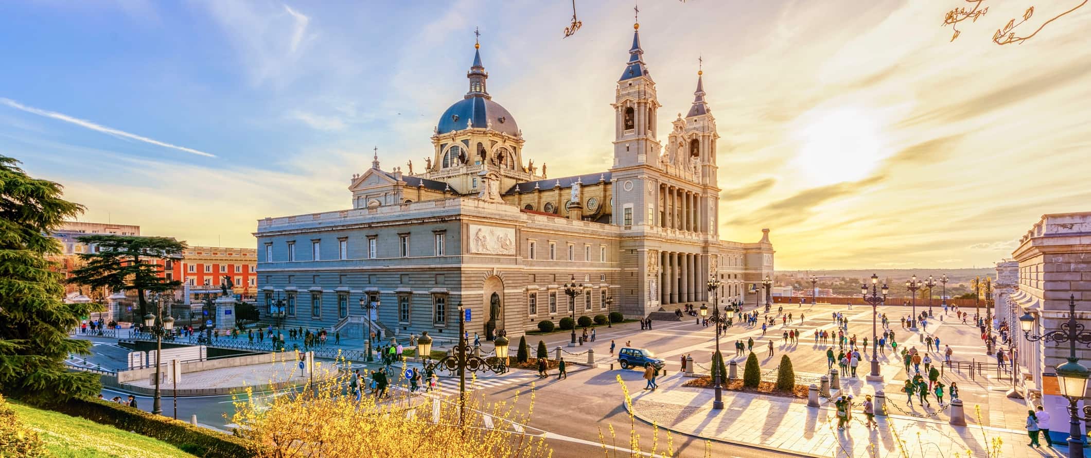 Impressionante arquitetura histórica de Madrid, Espanha, ao lado de uma grande praça durante o pôr do sol.