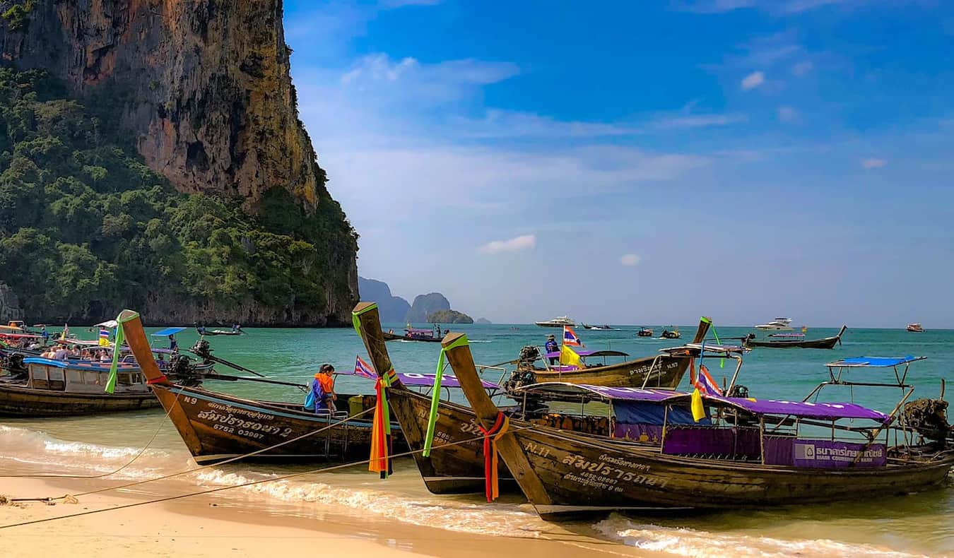Barcos com alongamentos longos estacionados em uma bela praia em uma das ilhas da Tailândia