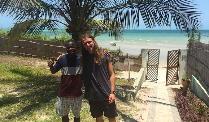 Dois viajantes posam para foto em Tofo, Moçambique
