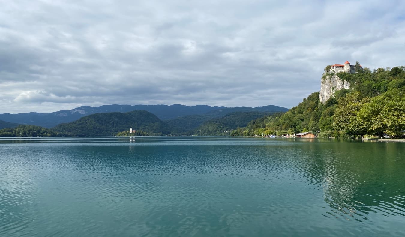 A vista do lago está na Eslovênia com fechaduras e montanhas ao fundo