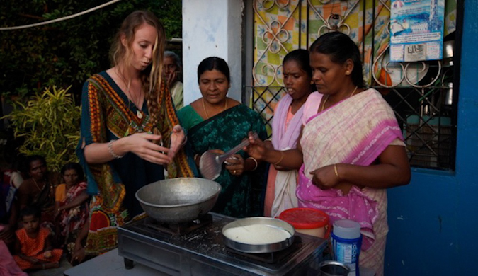 Viajante solitária cozinhando comida indiana com moradores locais