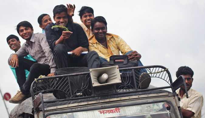 Um grupo de moradores locais no teto de um carro enquanto dirigia