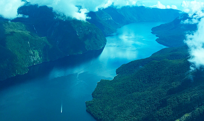 Vista do fiorde do lado do hidroavião voando sobre Fjordland na Nova Zelândia