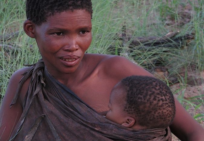 Foto de uma mulher de um arbusto com uma criança no Botsuana, África do Sul