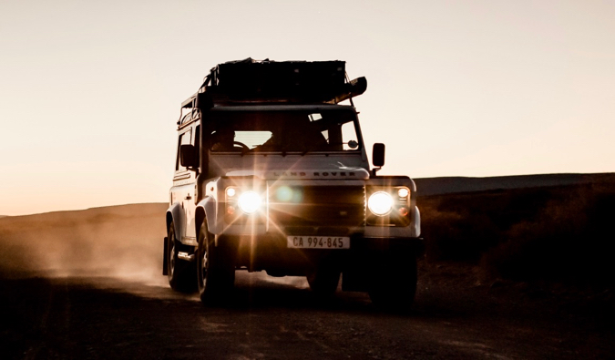 O Jeep Safari-Tour viaja por uma estrada empoeirada na África