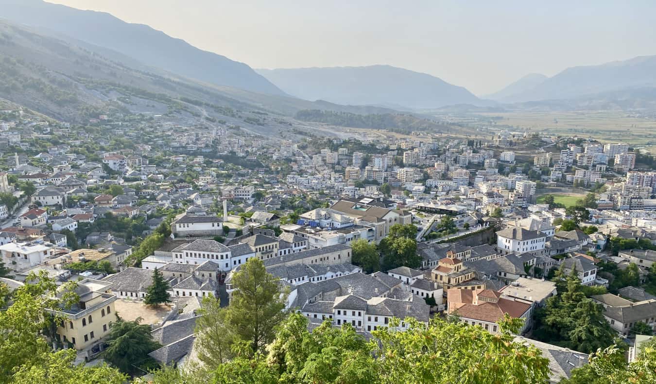 Vista de uma pequena cidade na Albânia cercada por montanhas exuberantes
