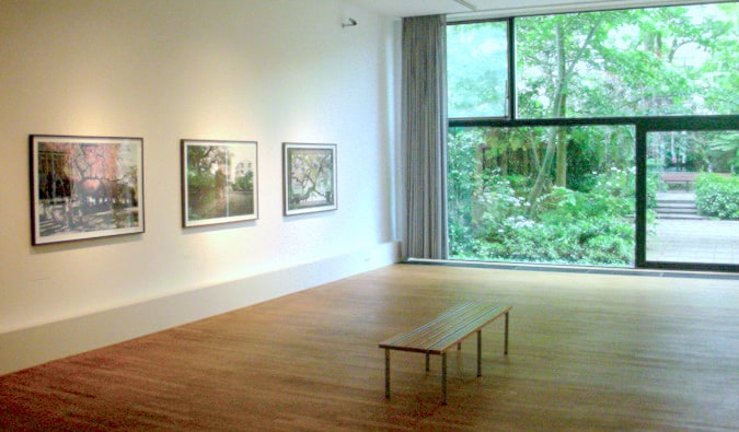 The Minimum Gallery Hall com fotos na parede e um banco para sentar no Museu de Espuma de Fotografia em Amsterdã