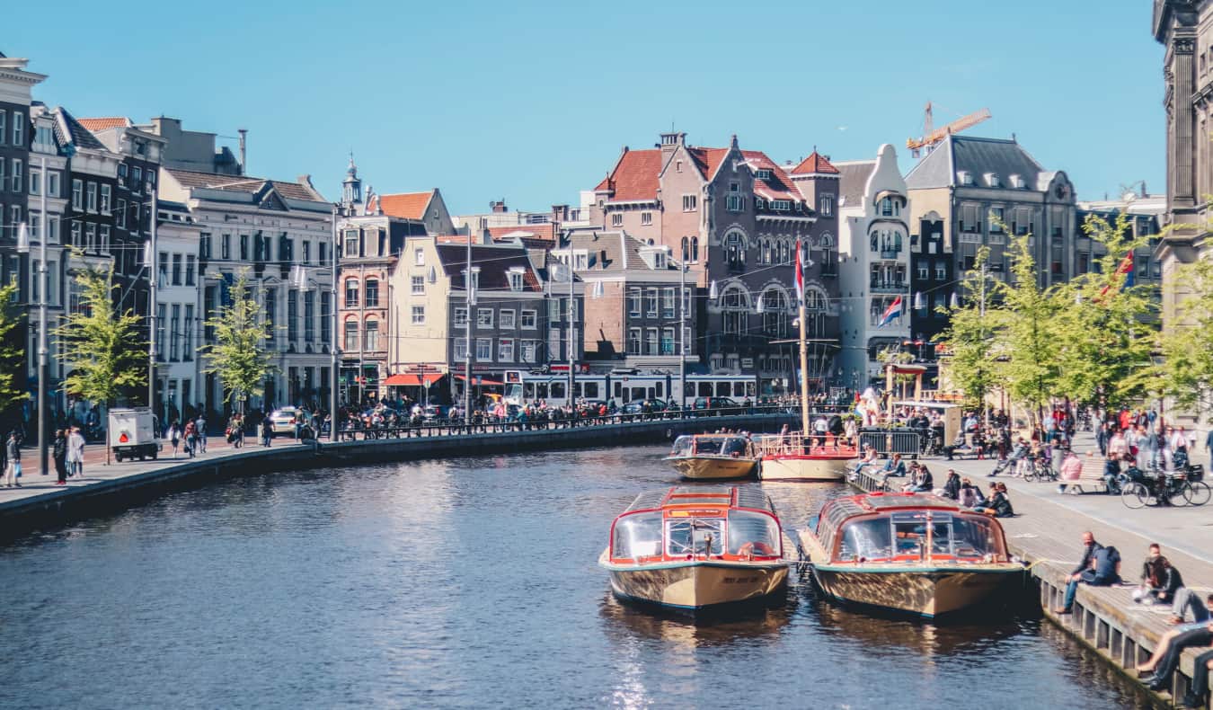 Canal estreito com barcos em Amsterdã em um dia ensolarado de verão
