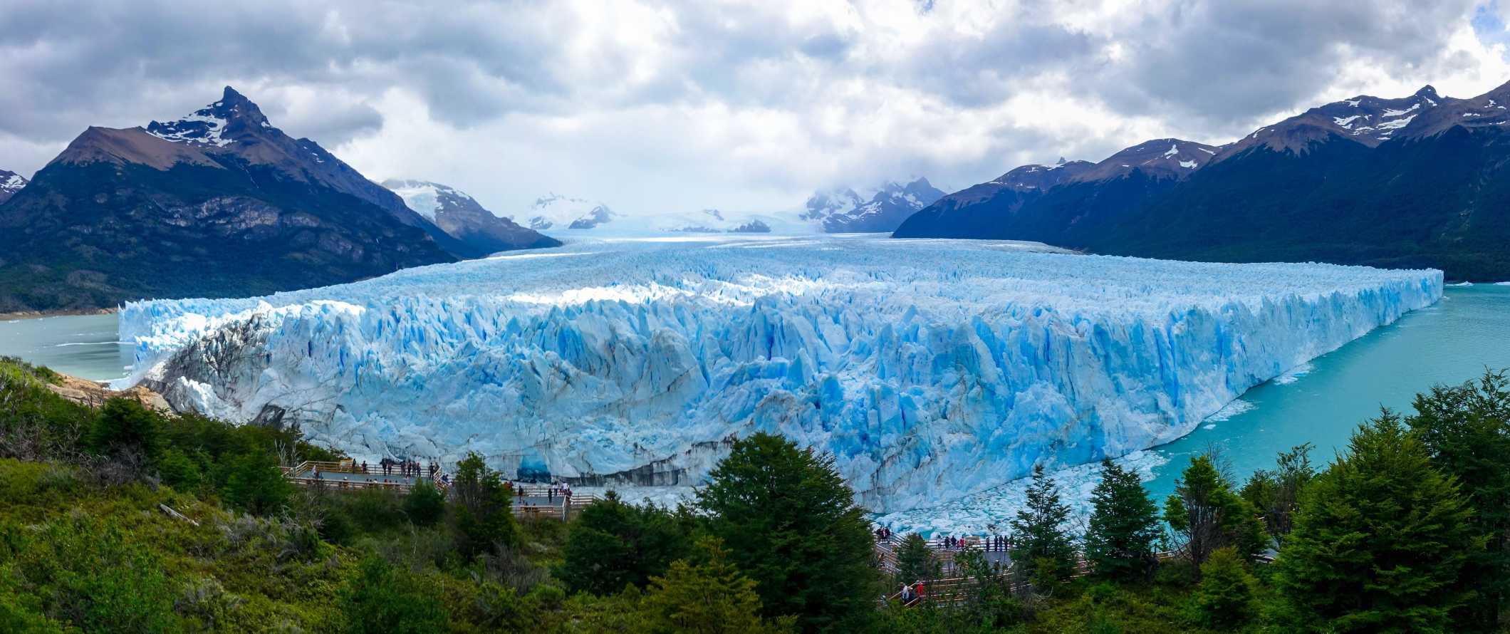 As incríveis e imponentes montanhas da Patagônia, Argentina, sob um céu azul claro, com uma grande geleira em primeiro plano.