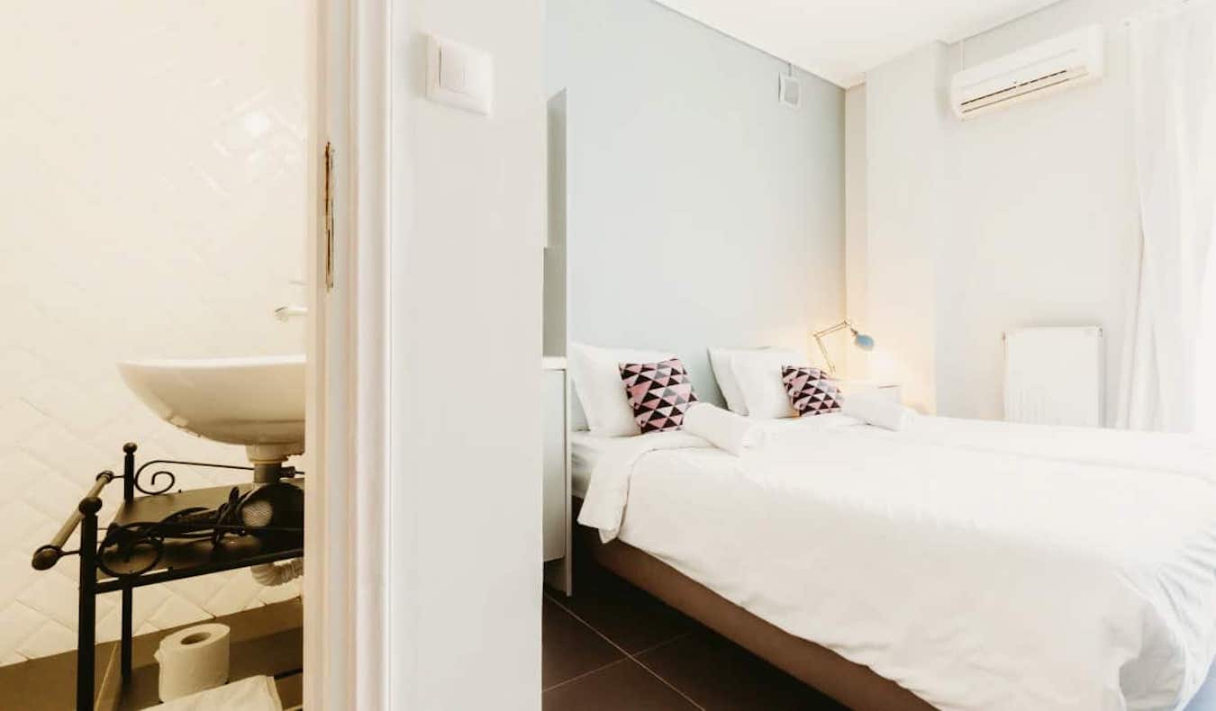 Espaçoso quarto privado no albergue Athens Studios na Grécia com uma grande cama branca