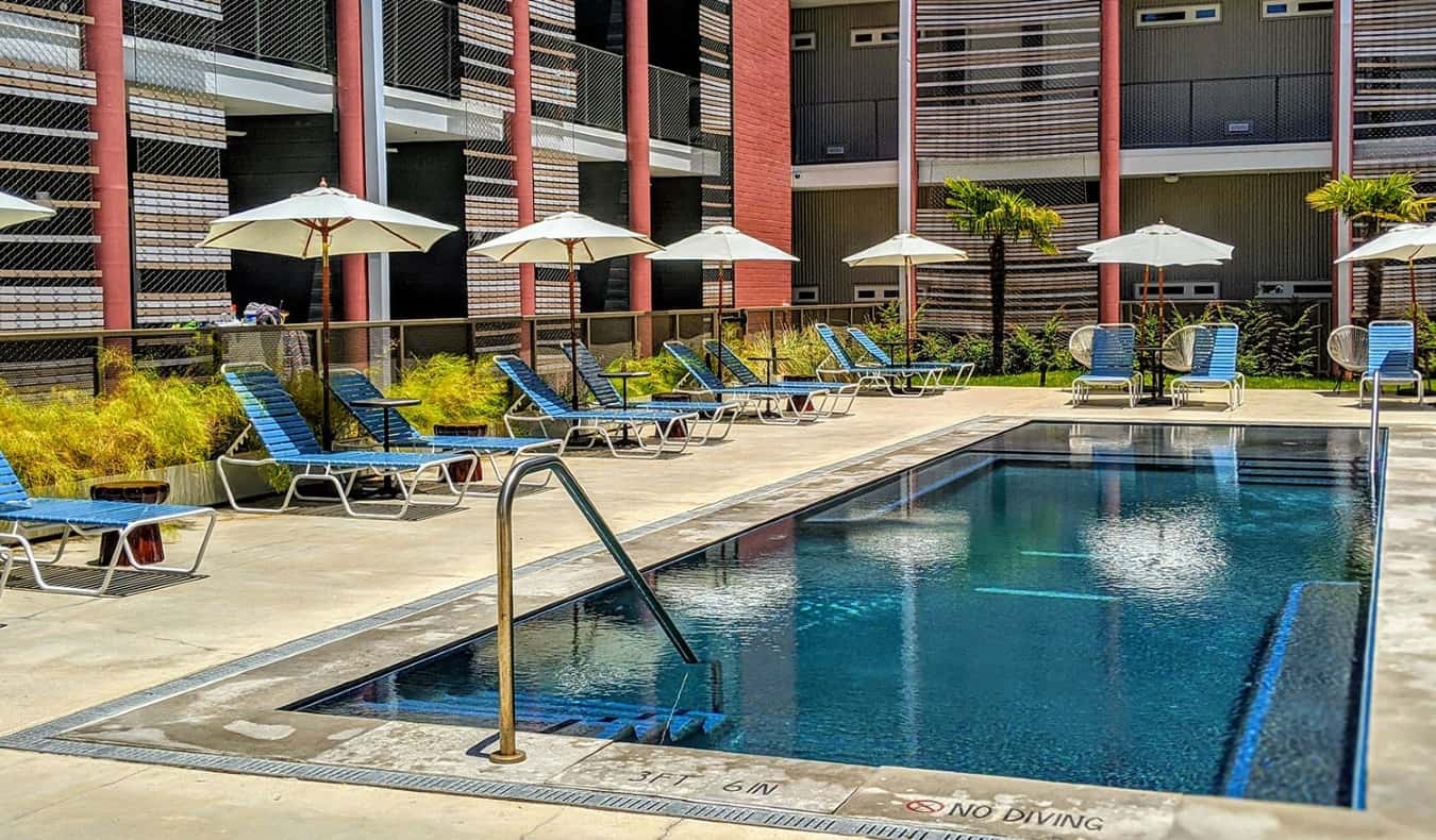 Uma pequena piscina aberta cercada por espreguiçadeiras no East Austin Hotel