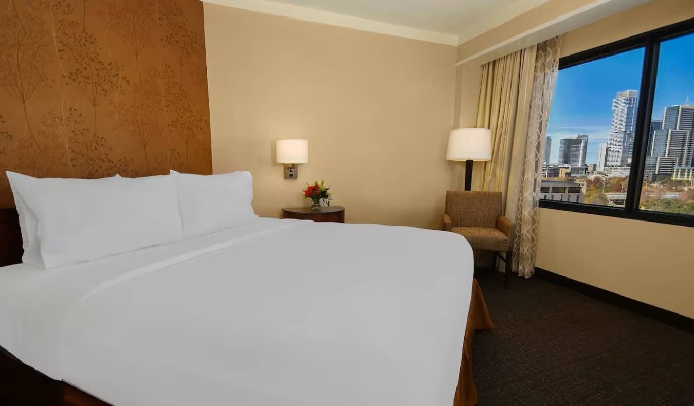 Quarto de hóspedes simples com uma cama de casal nas suítes da Embaixada do Hilton Hotel em Austin, Texas