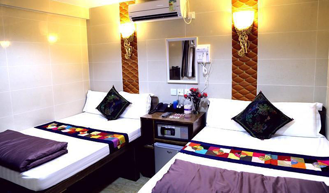 Duas camas de casal com frigobar entre elas em um quarto da Australia Guesthouse em Chungking Mansions em Hong Kong