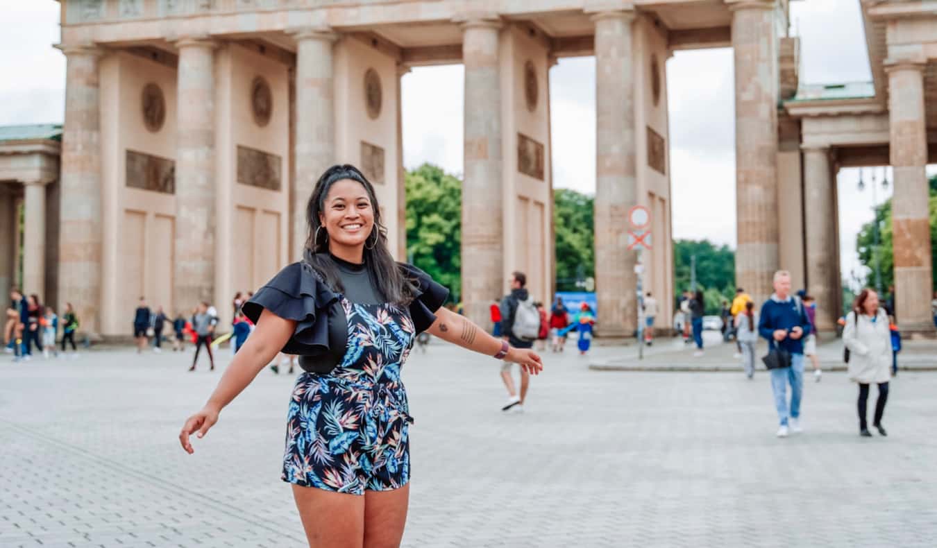 Um ávido viajante de Eva posa no portão de Brandenburgo em Berlim, Alemanha