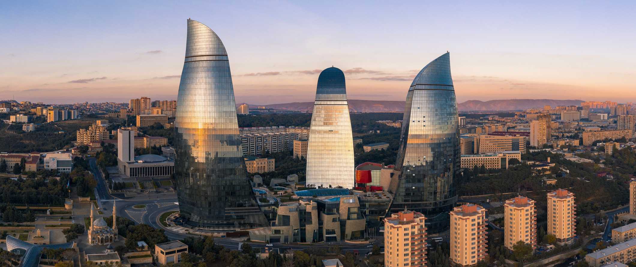 Torres de chamas em Baku, Azerbaijão, com vista para a cidade ao pôr do sol.