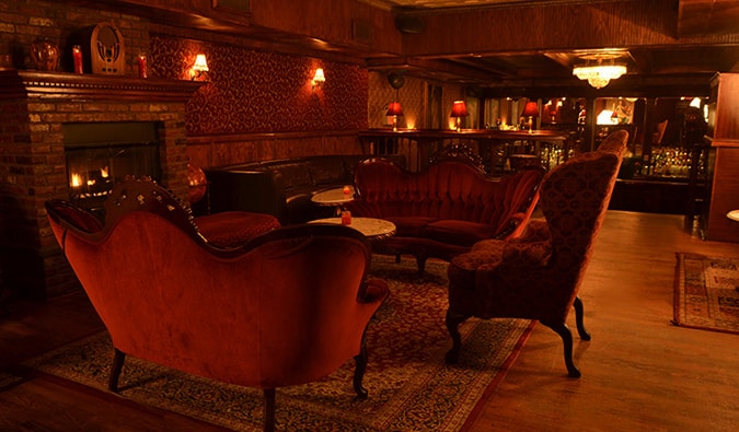 A sala dos fundos tem um bar elegante com um grande candelabro - uma atmosfera ideal para um bar proibido.