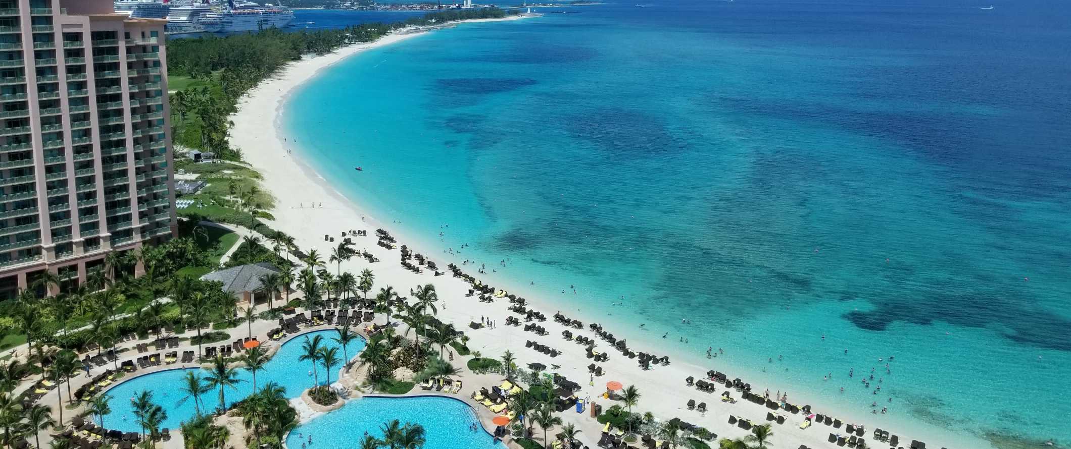 Vista de drone das piscinas do resort em um grande hotel ao longo da praia com água azul-turquesa cristalina nas Bahamas