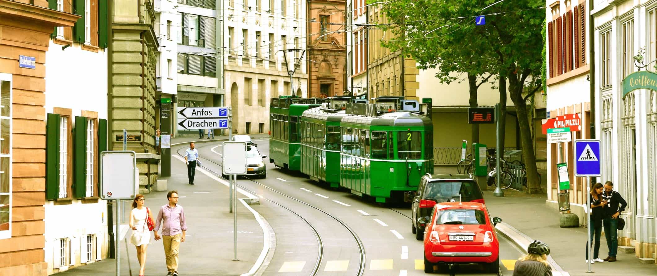 Rua curva com um bonde passando em Basileia, Suíça