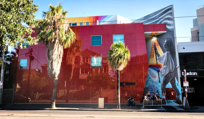 Exterior do albergue Base StKilda, agora Nomads, na Austrália, prédio vermelho com mural colorido