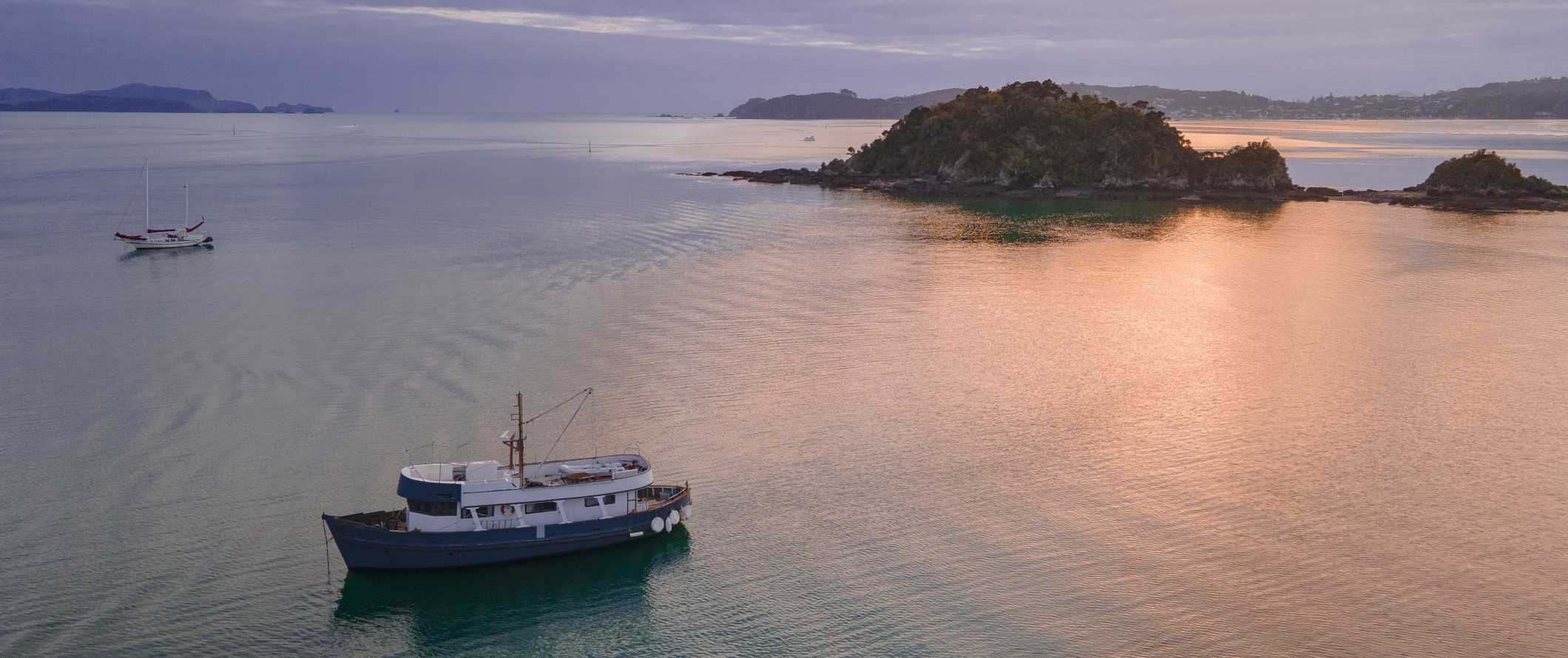 Os barcos picam entre ilhas no Golfo de Ilhas, Nova Zelândia