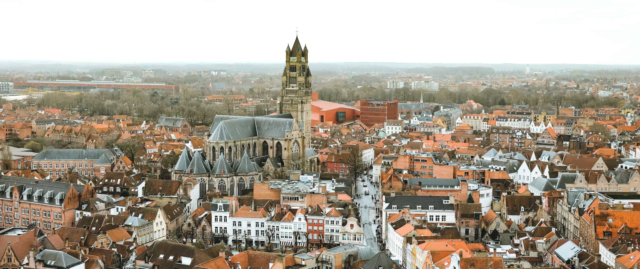 Vista panorâmica dos telhados vermelhos do centro histórico de Bruges com uma grande catedral de pedra no centro, Bélgica