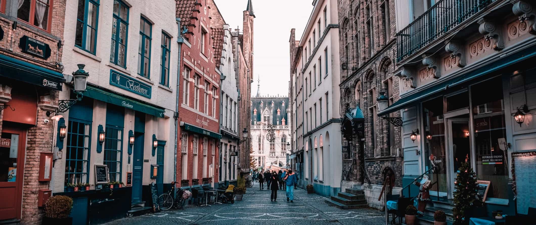 As pessoas seguem uma rua pavimentada de pedestres no centro histórico de Genta, Bélgica
