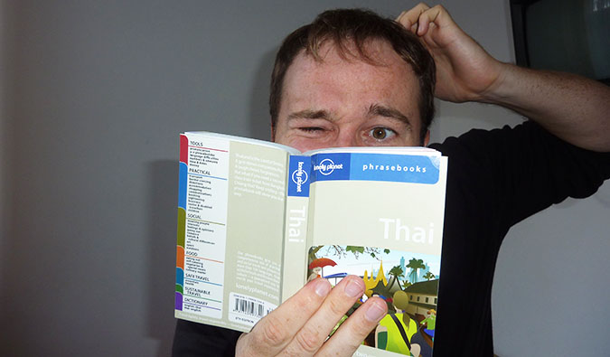 Benny estudando um livro de frases em tailandês
