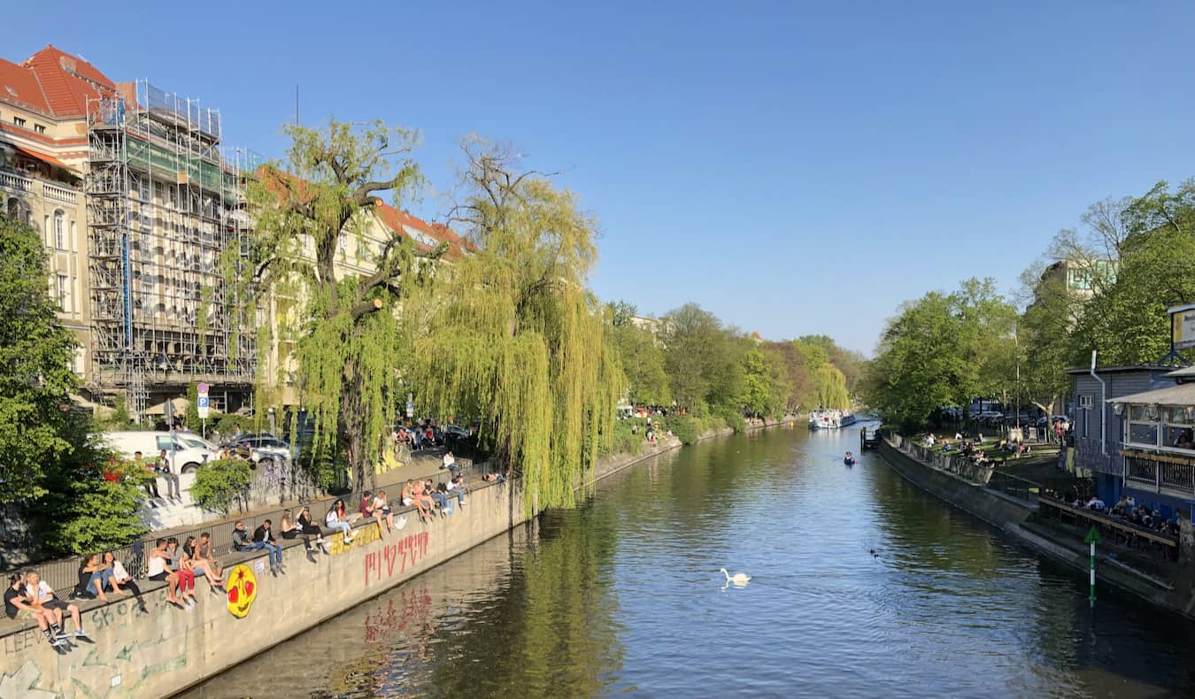 Moradores relaxam à beira do rio no charmoso bairro de Kreuzberg, em Berlim, Alemanha