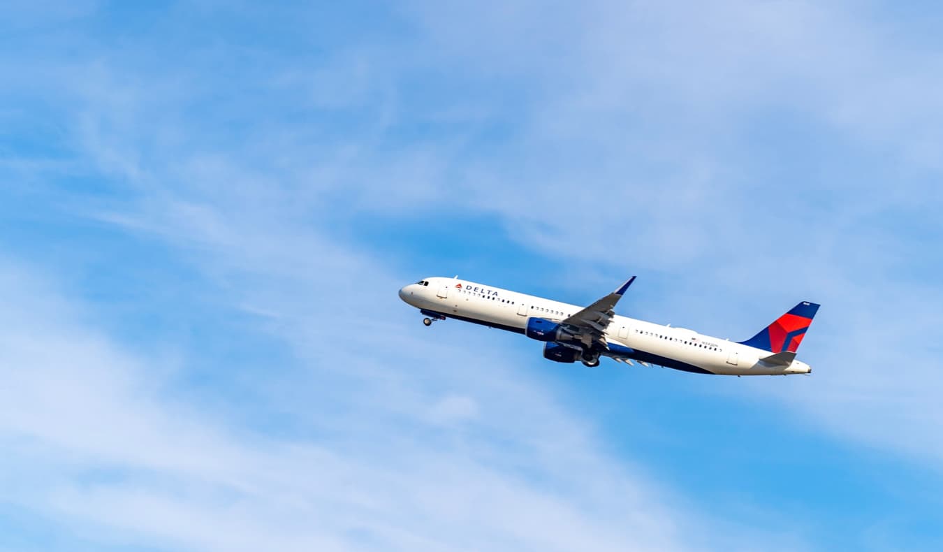 Aeronaves Delta Aeronaves sobe para o céu azul brilhante após a decolagem nos Estados Unidos