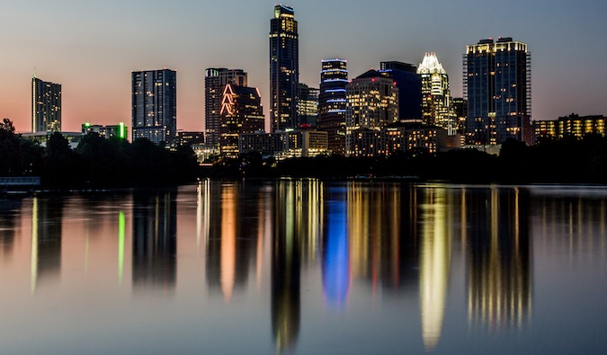 Horizonte de Austin, Texas, ao anoitecer, brilhando sobre a água