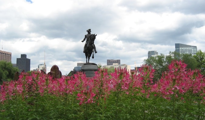 Estátua histórica cercada por flores em Boston, Massachusetts