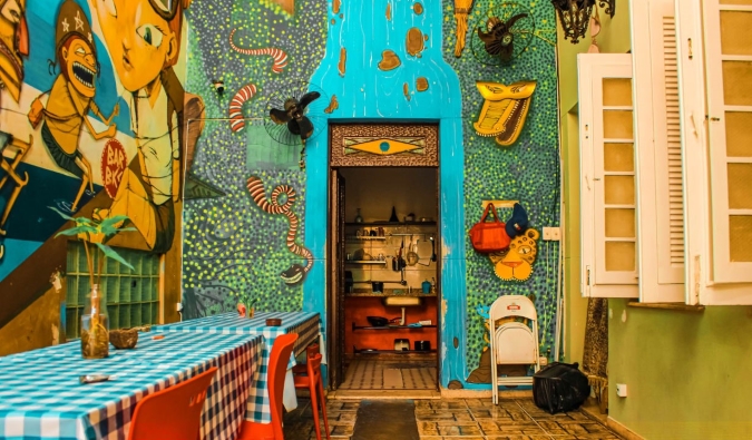 Uma cozinha pintada em cores vivas e coberta de murais no Books Hostel no Rio de Janeiro, Brasil