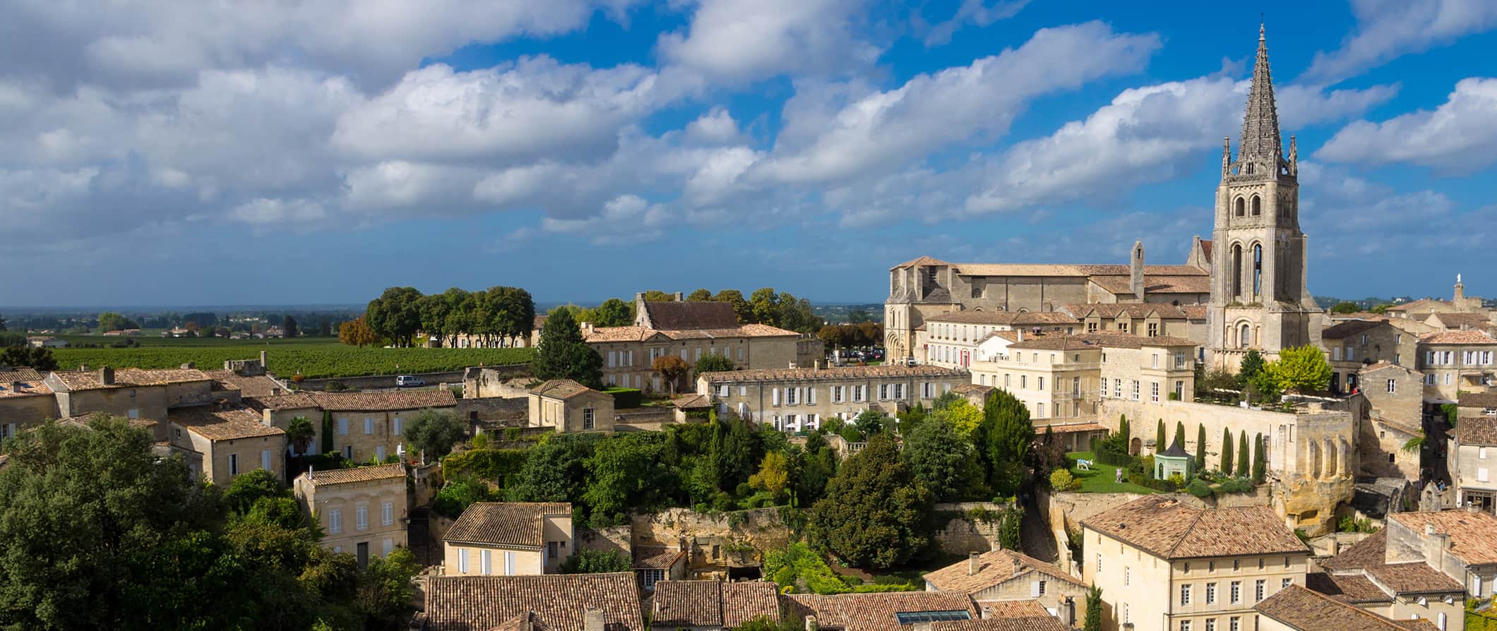 Telhados e horizonte de Bordeaux, França, com uma igreja imponente ao fundo em um dia ensolarado.