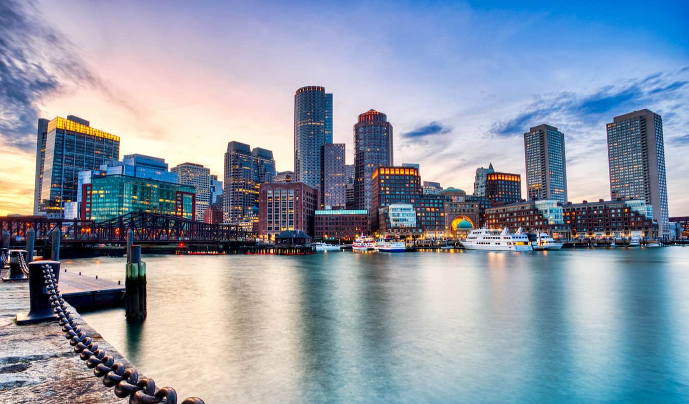 A linha horizontal de Boston, Massachusetts, é visível da água e um céu azul acima de sua cabeça.