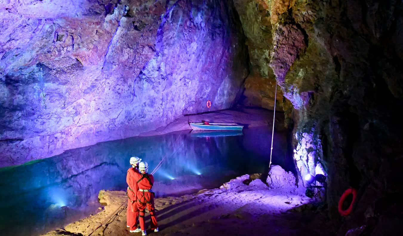 As pessoas exploram as cavernas coloridas de Vuki (cavernas wookey) perto de Bristol, Gr ã-Bretanha