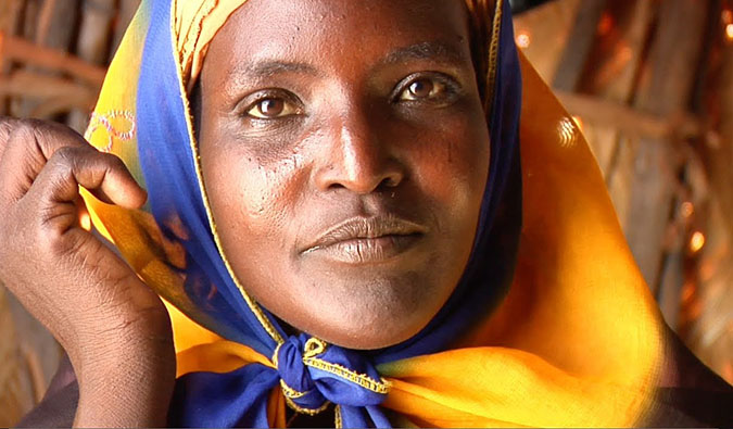 Uma mulher da África olha para a câmera durante as filmagens do filme 