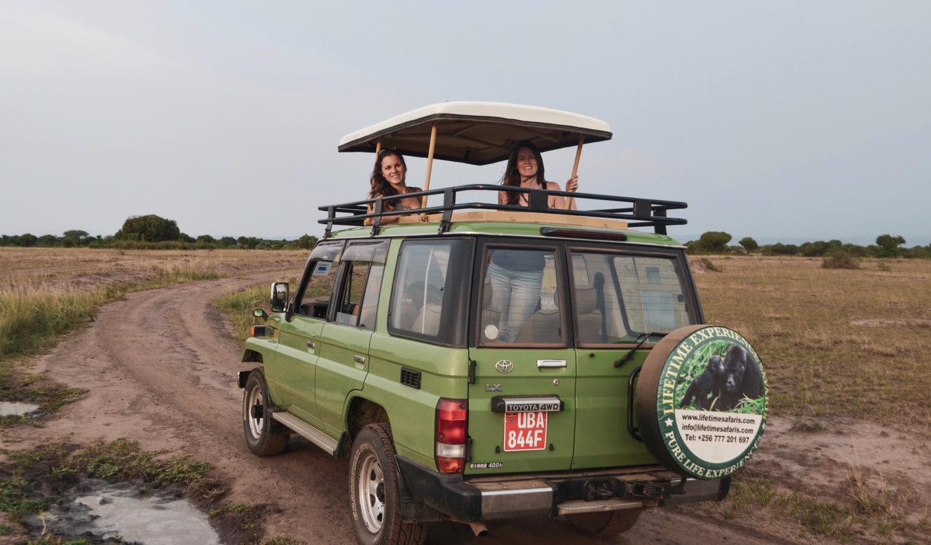 Duas mulheres viajantes no Safari em Uganda ficam em um jipe