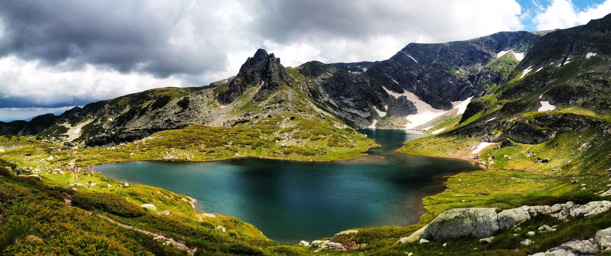 Lago verde esmeralda com picos pontiagudos ao fundo nas montanhas de Rila, Bulgária