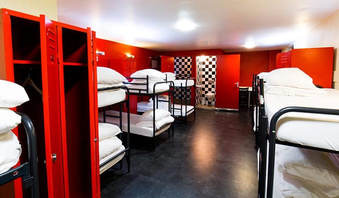 Um quarto em um albergue com paredes vermelhas brilhantes e muitos beliches no Bulldog Hotel