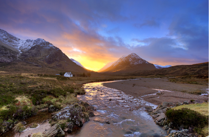 Fotografia de um rio e uma montanha e um pôr do sol colorido