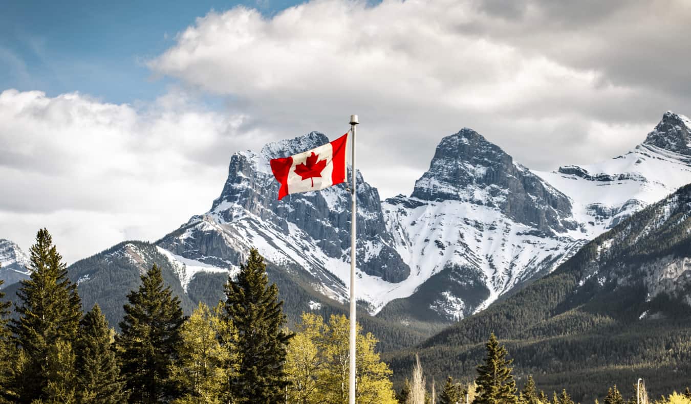 Bandeira canadense acenando perto de uma montanha nevada