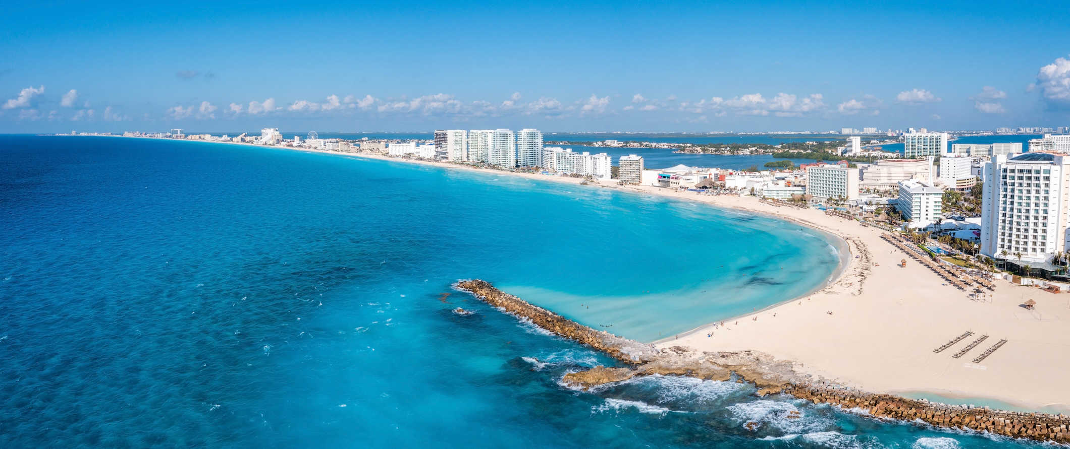 Litoral deslumbrante da ensolarada Cancún, no México, com resorts à beira-mar e barcos no oceano