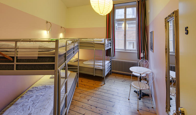 A sala comum principal com beliches e um piso de madeira no albergue Castanea Old Town, Estocolmo