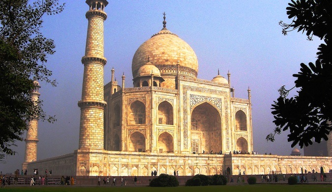 O icônico Taj Mahal em um dia ensolarado na Índia cercado por turistas