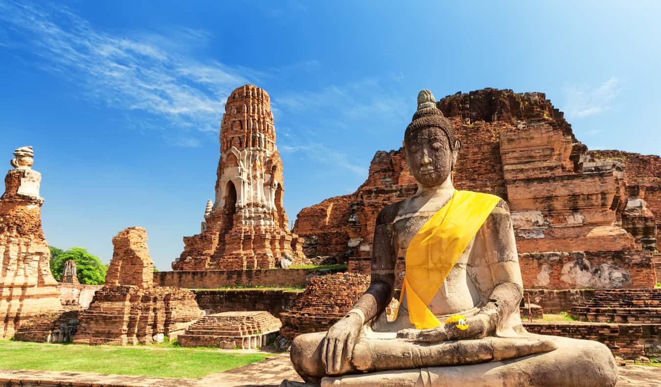 Estátua antiga do Buda com uma faixa em um lugar histórico em Solor Tailândia