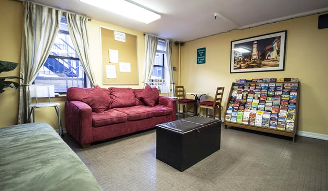 A principal zona comum com sofás e prateleiras com folhetos no albergue do Chelsea, em Nova York.