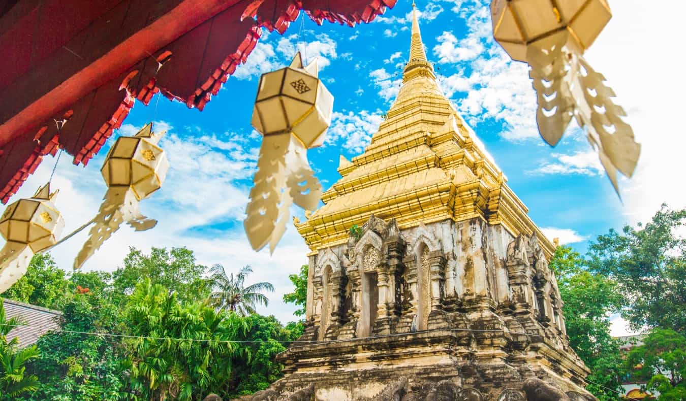 Templo budista com bandeiras agitadas no cenário do céu ensolarado em Chiangmai, Tailândia