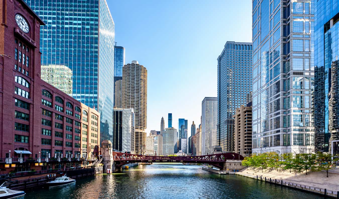 O animado centro de Chicago, os EUA, dividido pelo rio, em um dia ensolarado tranquilo com uma ponte à distância.