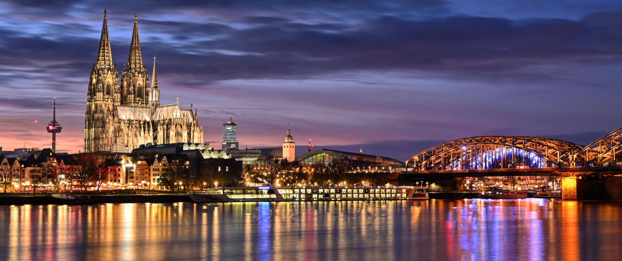 Vista da famosa catedral e ponte iluminada à noite em Colônia, Alemanha