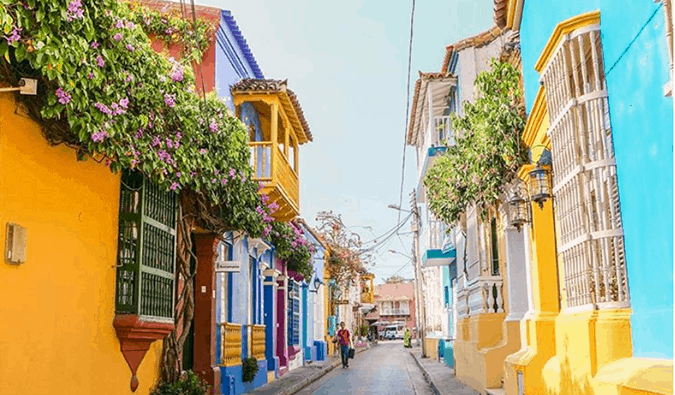 Casas pintadas com cores vivas e jardins floridos suspensos em uma rua estreita em Cartagena, Colômbia